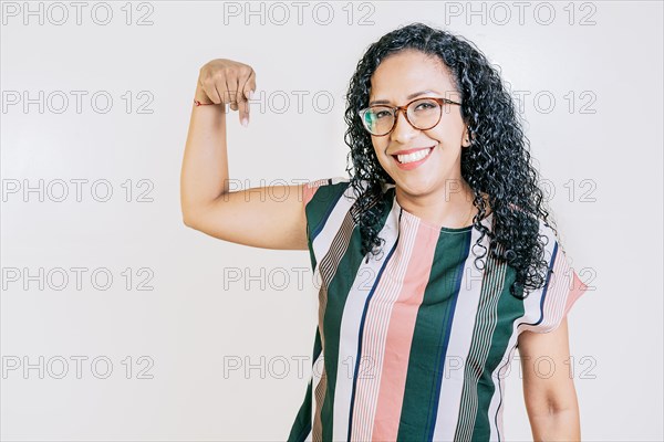 Smiling Latin woman pointing down an advertisement. Happy girl in glasses pointing finger down. Latin people pointing down at a banner