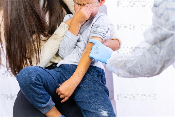 Crying child after vaccination injection by a female doctor. Vaccination of children. Immunization in the coronavirus pandemic