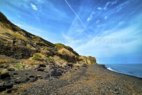 Dramatic landscape of blue sea or ocean waves rolling on rocky volcanic beach on cloudy day. Blue sky