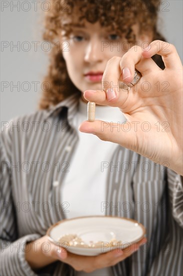Young woman stretched out her hand with vitamin pill
