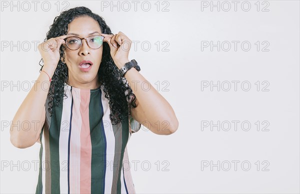 Surprised woman taking off glasses isolated. Amazed afro girl taking off glasses by a promotion