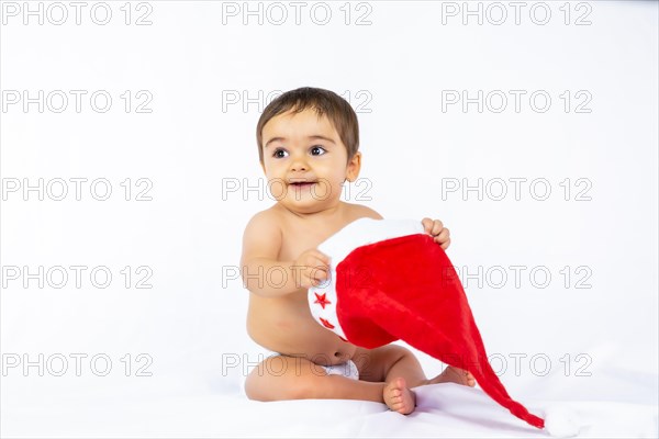 A baby boy with a red Christmas hat on a white background