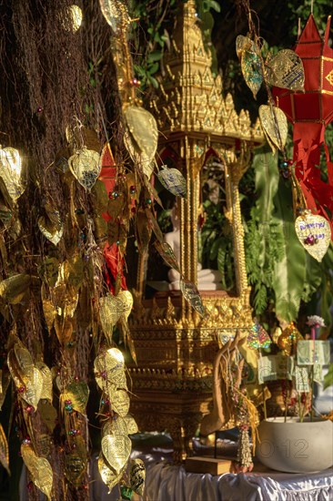 Traditional Thai Buddha altar as busabok with money and incense sticks offerings
