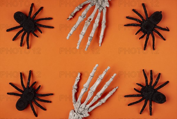 Black spiders and skeleton hands on orange