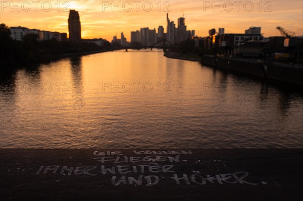 WE CAN FLY. ALWAYS FURTHER AND HIGHER. is written on a railing of the Deutschherrn Bridge in Frankfurt's Osthafen area