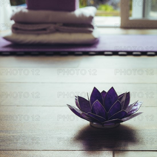 Glass lotus decorative on a woodn floor. Yoga concept