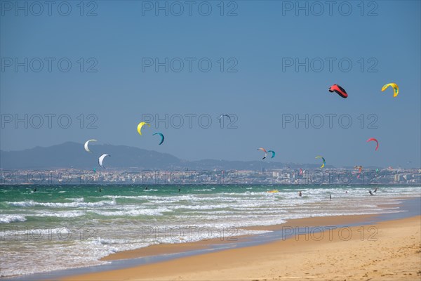 Kiteboarding kitesurfing kiteboarder kitesurfer kites on the Atlantic ocean beach at Fonte da Telha beach