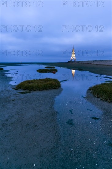 Kugelbake illuminated with water reflection at dusk