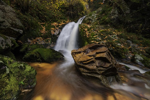 Mountain stream with waterfalls in autumn