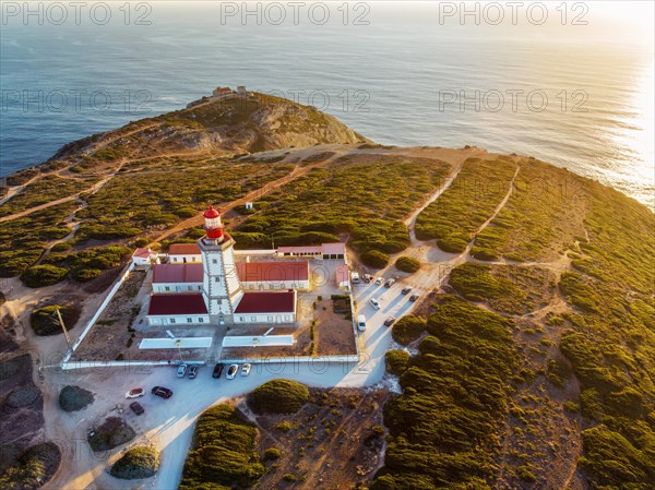 Aerial drone view of lighthouse on Cabo Espichel cape Espichel on Atlantic ocean at sunset. Sesimbra