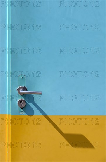 Yellow-cyan iron door with lock and door handle with shadow
