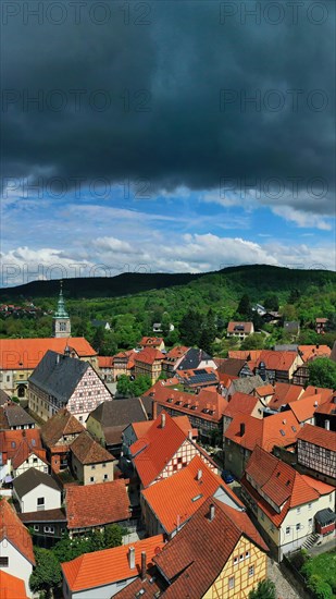 Aerial view of Koenigsberg in Bavaria. The city is surrounded by hills and forests. The sky is cloudy and dark