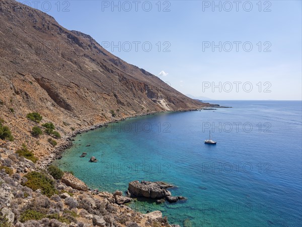 Sailboat anchored in a bay next to the E4 long-distance footpath along the rocky coast to Chora Sfakion