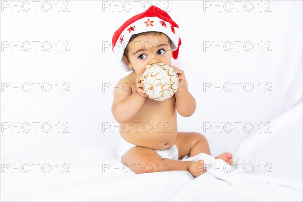 A baby boy with a red Christmas hat on a white background