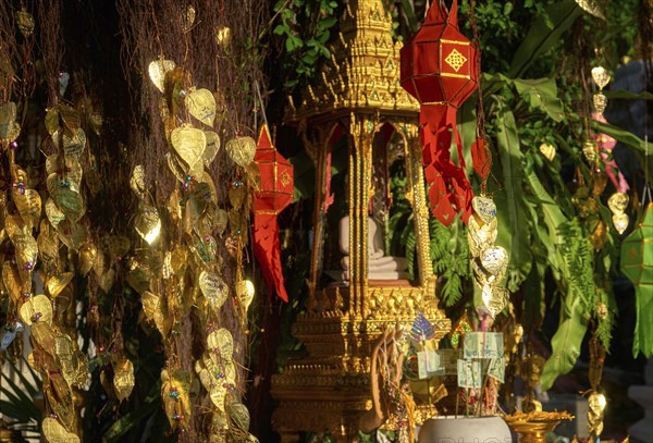 Traditional Thai Buddha altar as busabok with money and incense sticks offerings
