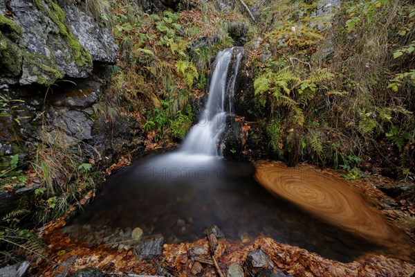 Mountain stream and waterfall in autumn forest
