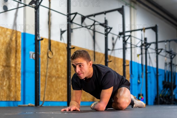 Disabled man stretching his back after exercising in a cross training gym
