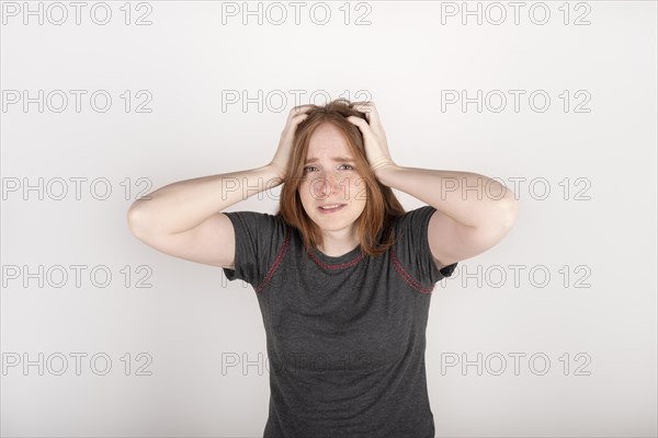 Red haired woman clutching her head