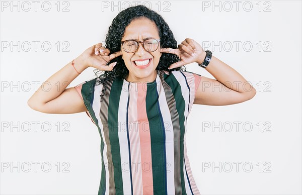 Young woman covering her ears tightly. Displeased girl in glasses covering her ears isolated