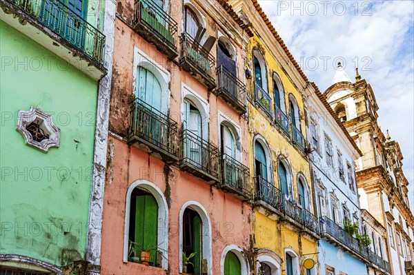 Facades of colorful houses and church in baroque and colonial style damaged by time in the Pelourinho neighborhood in the city of Salvador