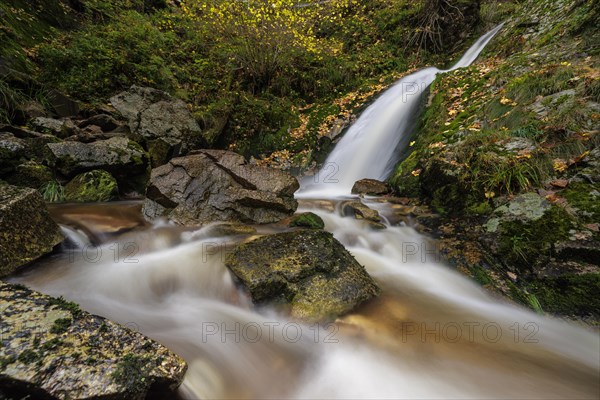 Mountain stream with waterfalls in autumn