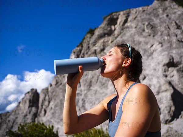 Young woman drinking from an outdoor bottle