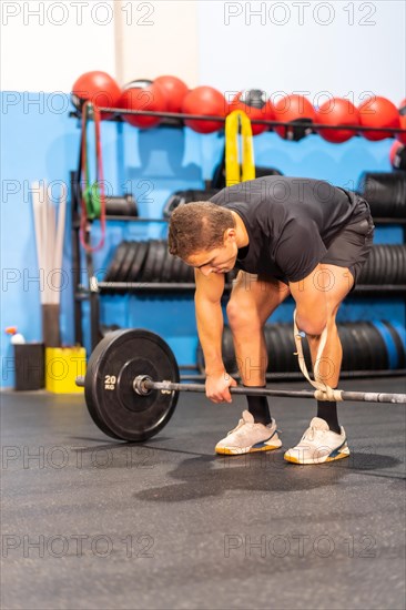 Vertical photo of a disabled man lifting weights with an arm amputated