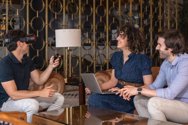 Coworkers using virtual reality glasses during a meeting in an hotel