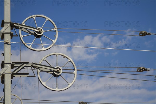 Railway line mast with wheel tensioning station