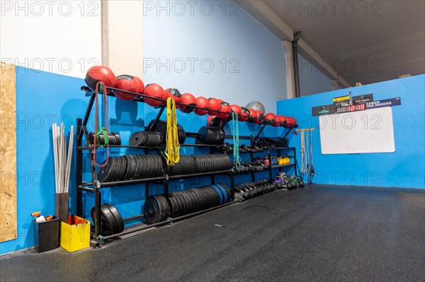 Rack with medicinal balls and weights in a cross training gym without people