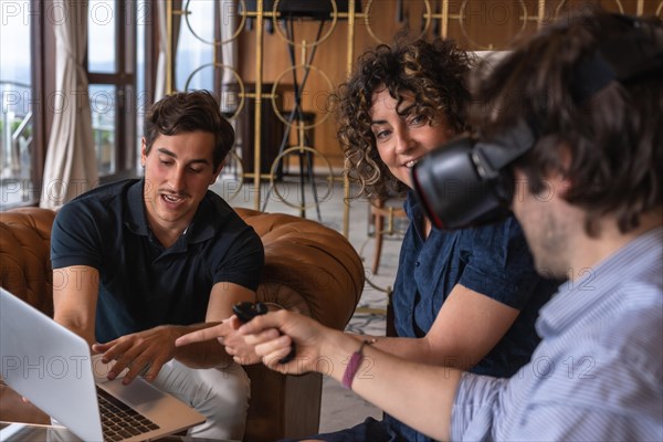 Close-up of a young business team presenting new project to a client on a virtual reality simulator in a hotel hall