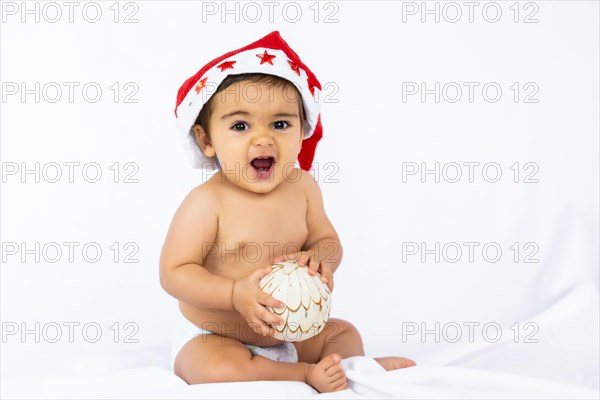 A baby boy with a red Christmas hat on a white background