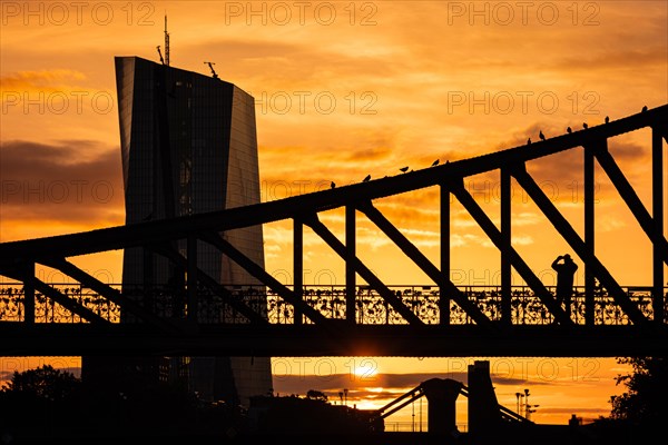 The sun rises behind the European Central Bank