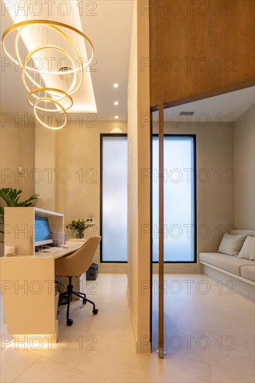 Vertical photo of en elegant entrance of a clinic with reception and waiting room