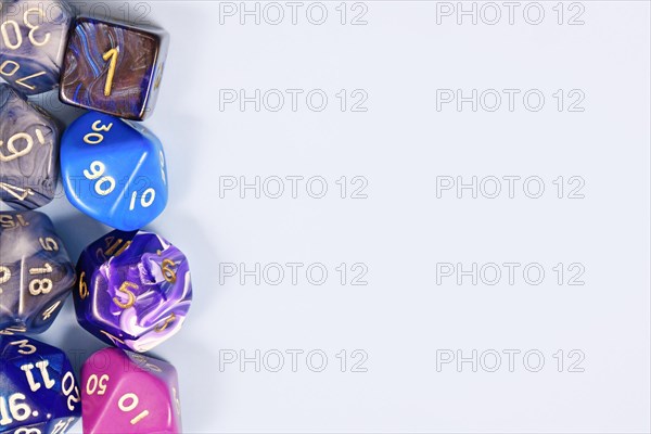 Blue and purple roleplaying game RPG dice on side of light gray background with blank copy space