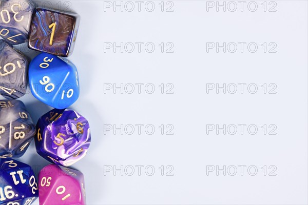 Blue and purple roleplaying game RPG dice on side of light gray background with blank copy space