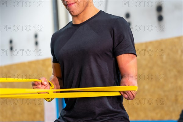 Close-up of a handicapped man using an elastic band to work out in a cross training gym