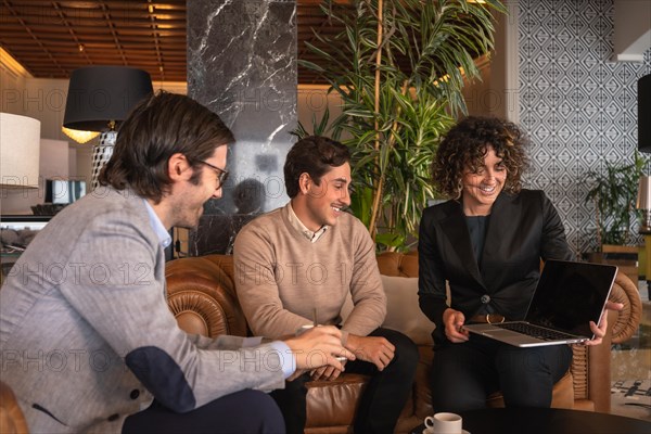 Colleagues looking at the laptop during a business meeting in an hotel