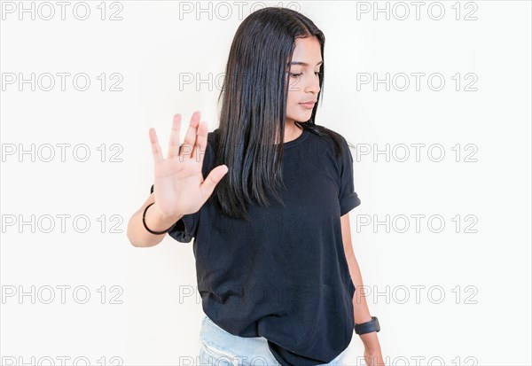 Young girl gesturing stop with palm of hand isolated. Teenage girl rejecting with the palm of her hand. Latin people gesturing stop isolated