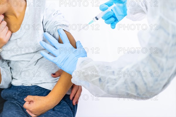 A female doctor calming the child with his mother before the vaccine injection. Vaccination of children. Immunization in the coronavirus pandemic