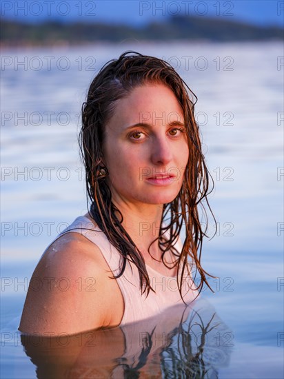 Young woman with wet long hair in the water