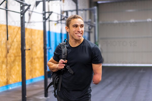 Happy man with one arm amputated on his way to the gym