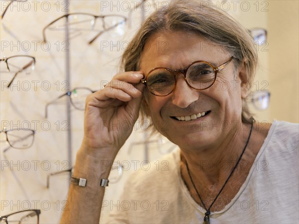 Man at optician trying on new glasses