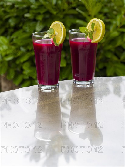 Freshly squeezed juice of beetroot with apple and lemon in a juice glass