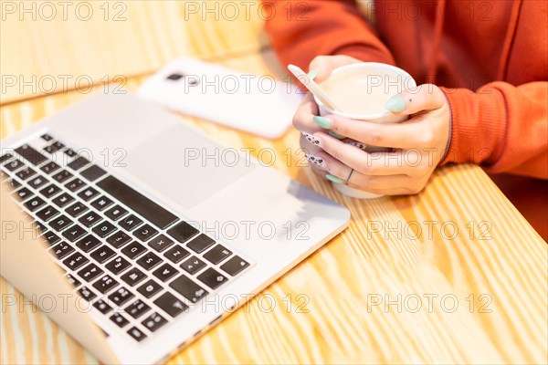 Alternative unrecognizable person with a hot coffee surfing the internet on the computer