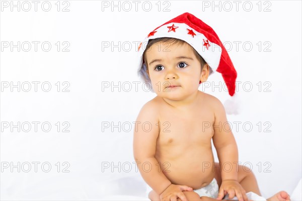 A baby boy with a red Christmas hat on a white background