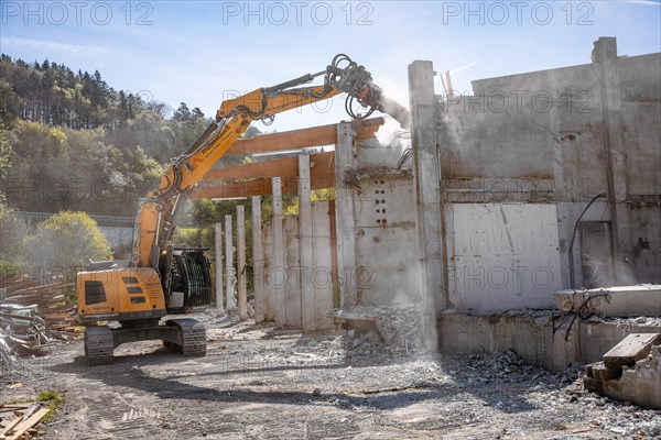 Yellow Liebherr crawler excavator recycling on demolition site