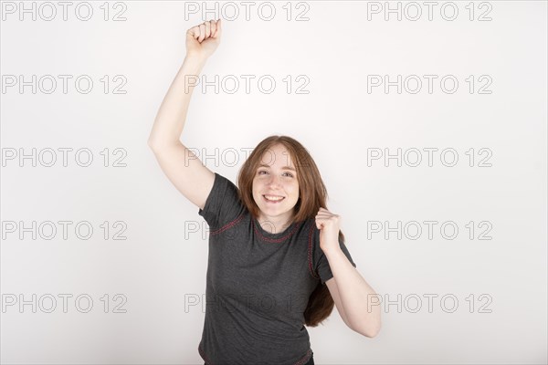 Portrait of young red haired woman celebrating
