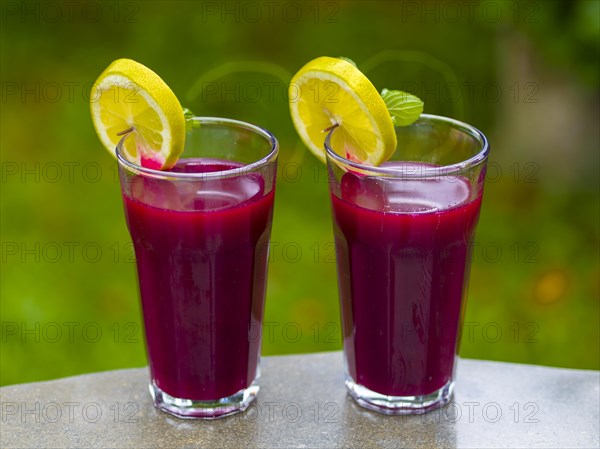 Freshly squeezed juice of beetroot with apple and lemon in a juice glass