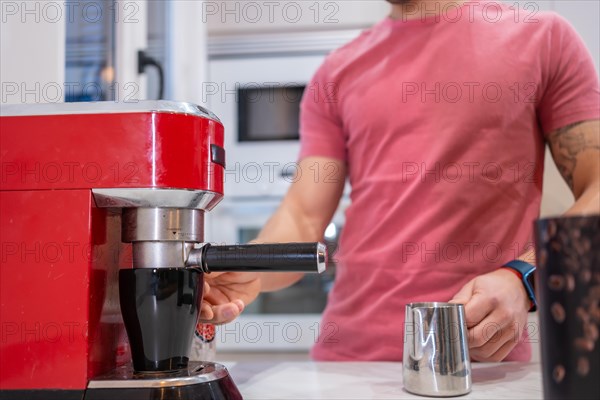 Cropped photo of an unrecognizable man making coffee at home with an electric coffee machine